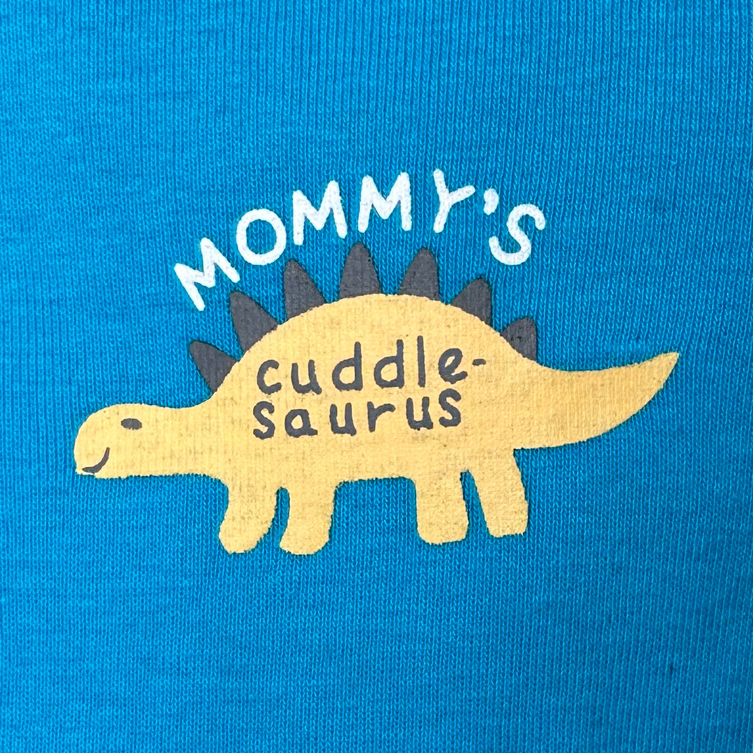 blue baby bodysuit, dinosaur baby bodysuit, Mommy's Cuddle-Saurus onesie, cotton baby bodysuit, short sleeve baby outfit, baby onesie with snap buttons, comfortable baby clothing, dinosaur-themed baby bodysuit, baby gift idea, newborn baby clothes, everyday baby wear, baby boy bodysuit, soft cotton baby onesie, easy diaper change baby bodysuit, playful baby clothing.